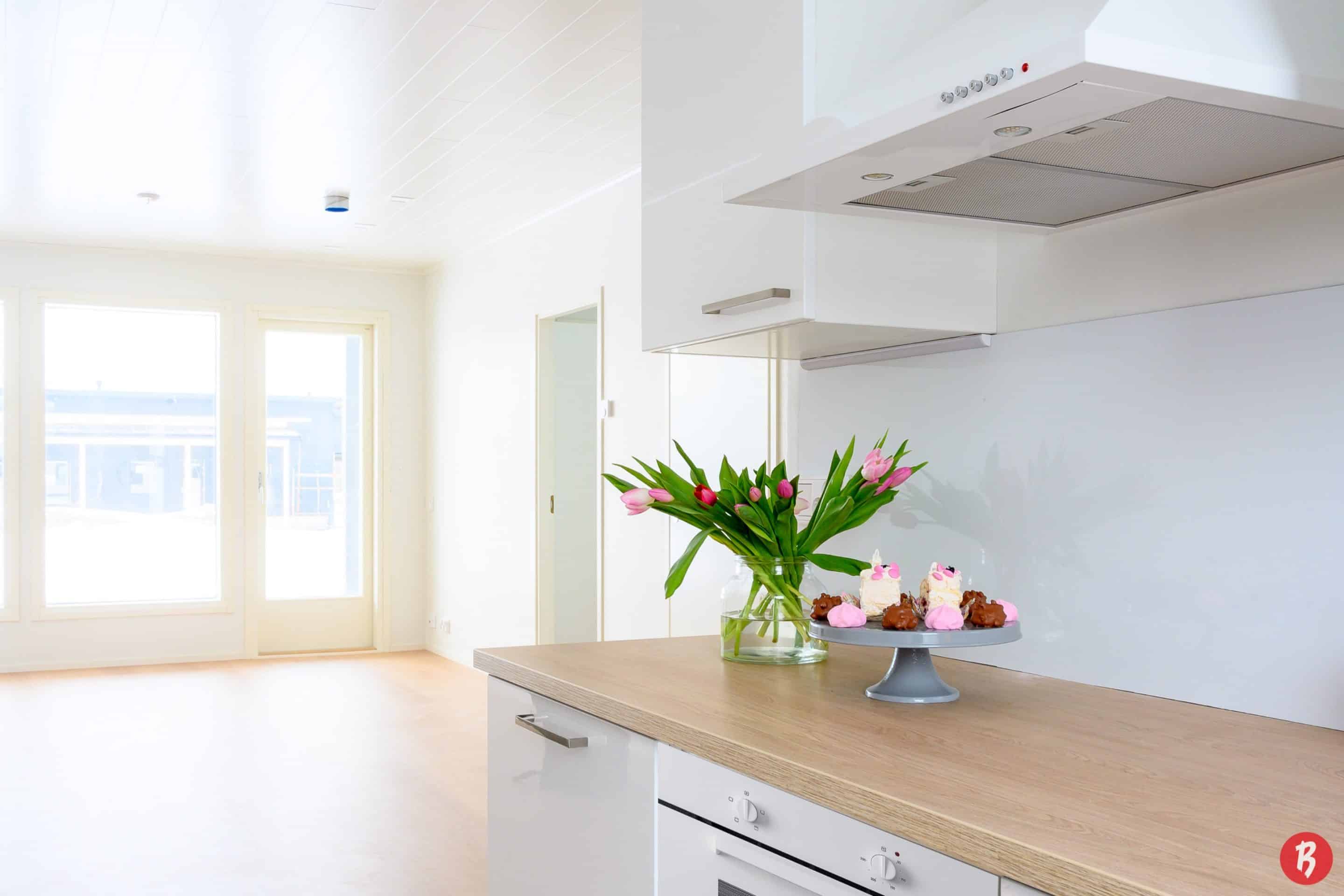 Sisakuva uuden muuttovalmiin omakotitalon, rivitalon tai paritalon skandinaavisen modernista keittiosta.